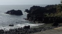 静岡県伊東市、城ヶ崎海岸の穏やかな磯場と黒い溶岩石の風景